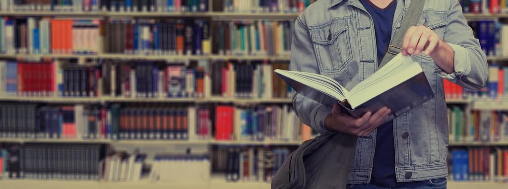 Studenci korzystający z materiałów edukacyjnych w bibliotece